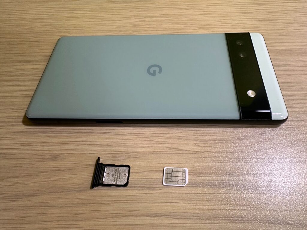 Google Pixel 6aとSIMトレイとSIMカードの写真